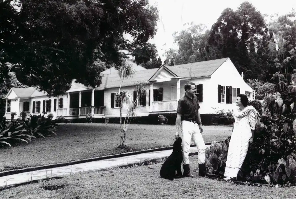 Historic photo of the Ulupalakua Ranch house with a couple on the lawn