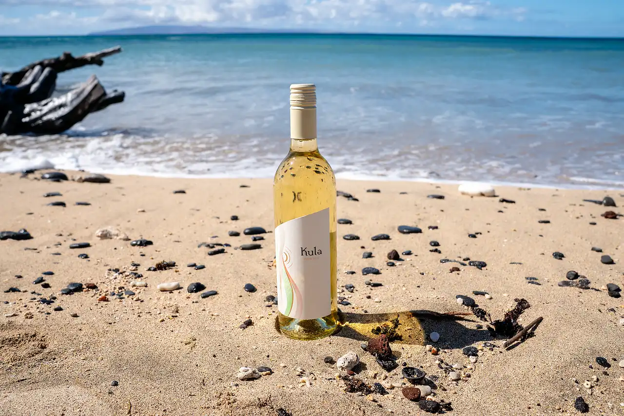 Bottle of Kula white wine on a sandy Maui beach