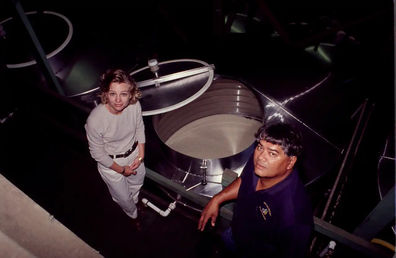 Historic photo of winemakers checking a tank of fermenting wine