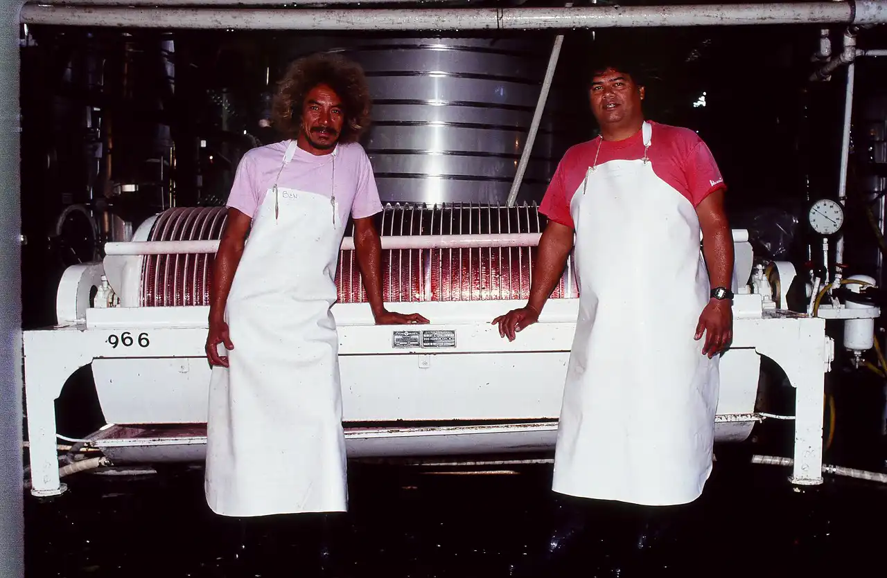 Historic photo of two winery workers at the grape press