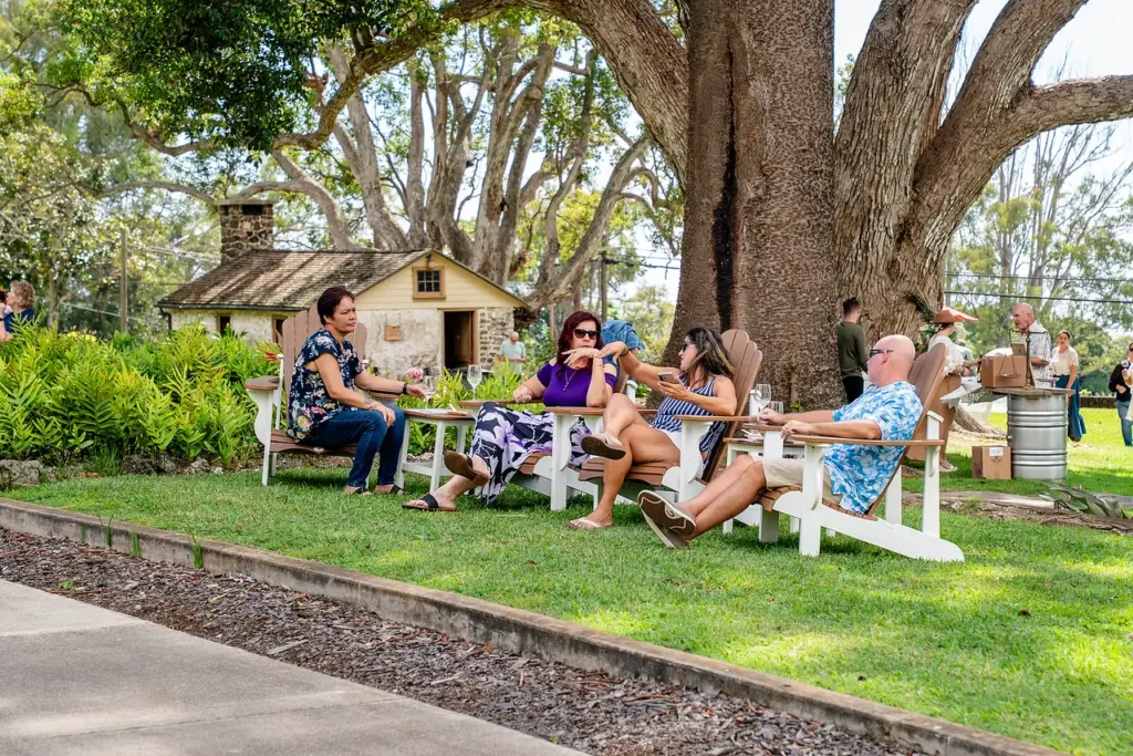 Guests relaxing on the lawn beneath the old camphor tree