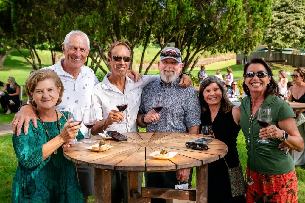 Wine club members toasting together at a garden table