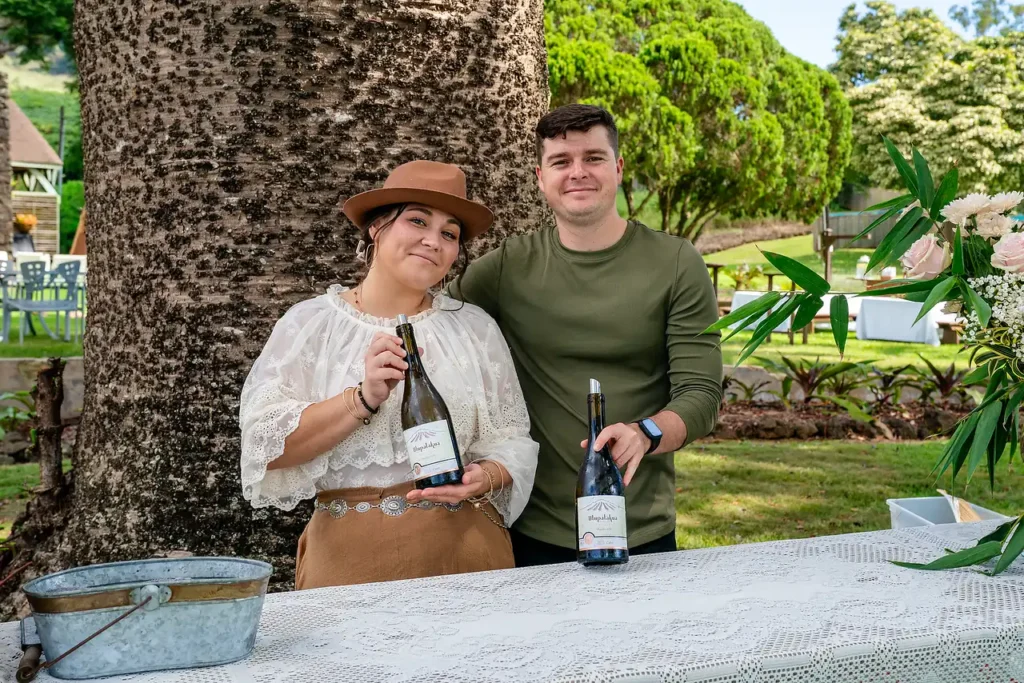 MauiWine staff pouring wine for a wine club event under a large tree