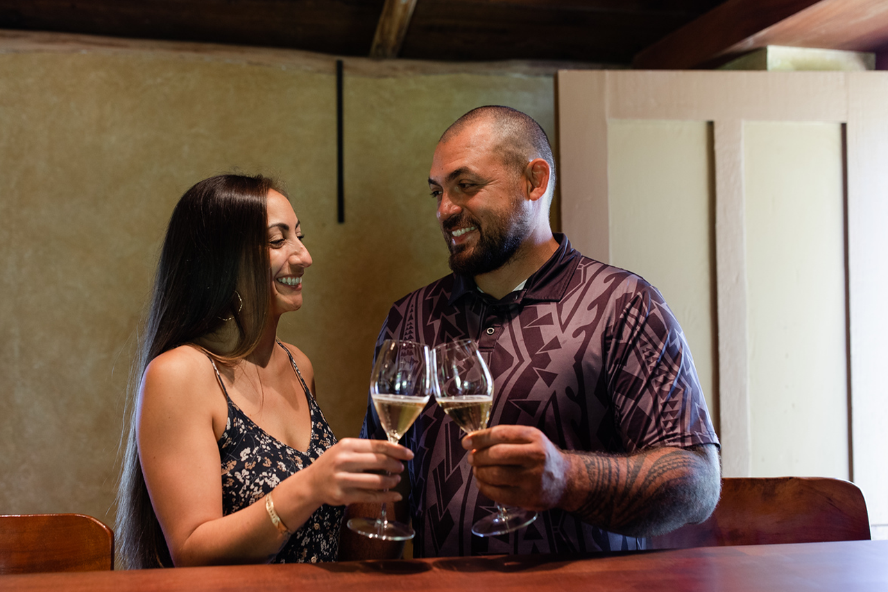 Couple toasting with white wine at the tasting room