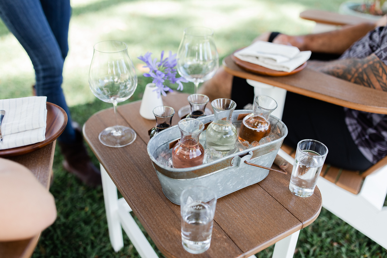 Wine tasting set with glasses and snacks on a garden table under the camphor tree